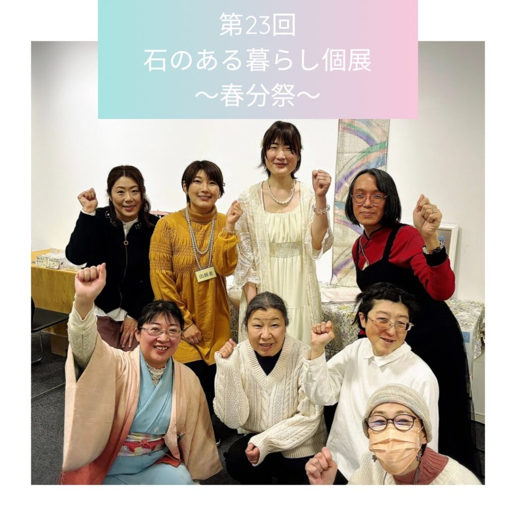 「石のある暮らし個展〜春分祭〜」で撮影された集合写真。前列に水色の着物を着た女性が微笑みながら拳を掲げている。
